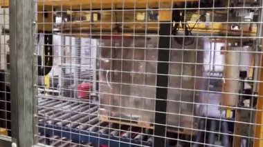 Ağır yük makinesi tarafından bir folyo ile bir palet sarma kutuları. Küçük. Ağır yük makinesi tarafından bir folyo ile bir palet sarma kutuları