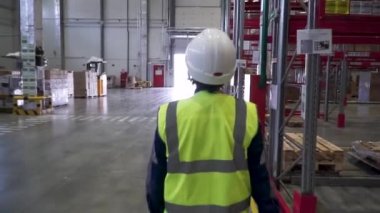 kadın depo işçisi kask ve güvenlik yeleği ile. Küçük. Koruyucu üniforma, kask ve gözlük fabrikasında çalışırken telsiz tutan genç erkek
