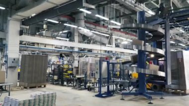 Çalışan bir depo ile forklift kamyon yüklü mal dağıtma. Küçük. Adam yükleme makinesi bitki işlemi sırasında sürüş