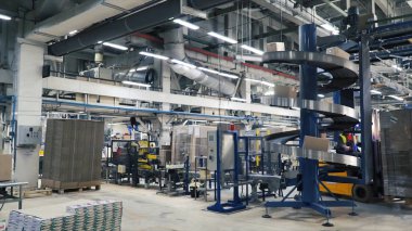 Çalışan bir depo ile forklift kamyon yüklü mal dağıtma. Küçük. Adam yükleme makinesi bitki işlemi sırasında sürüş