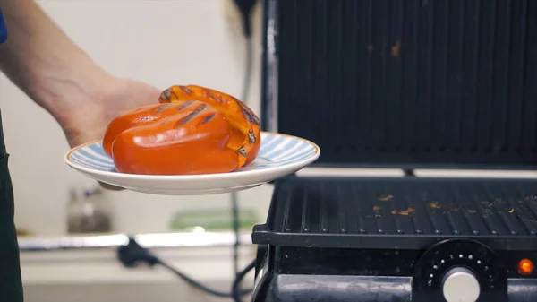 Vackert rostad röd paprika. Klipp. Grillad paprika beredning. Grilla grönsaker på grillen. Hälsosam mat måltid på flammande heta — Stockfoto