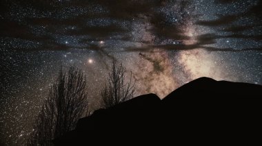 Monument Valley kaya üzerinde Timelapse fırtına ortaya koymaktadır. Star Galaxy spin kayanın arkasına rotaları. Samanyolu gece gökyüzü geniş Panorama. Timelapse Samanyolunun plaj üzerinde. Timelapse