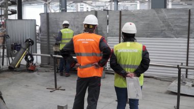 Gelecekteki açık havada planya yaratıcı inşaat işçileri. Küçük. İnşaat alanında ayakta Denetçiler