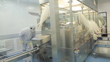 Önlük, şapka, eldiven kontrol sürecinde, fabrika üretim hattında tablet ile işçi. Kalite kontrol işçi inceleyerek hap Lab. ilaç laboratuar teknisyenleri kalitesini inceleme