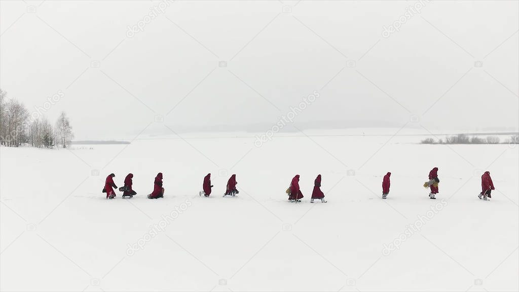 A group of people traveling on the taiga or snow-covered forest follow each other. Footage. Group of some people on winter hike in mountains, backpackers walking on snowy forest
