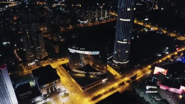 ライトアップされた高層ビル群の幻想的な夜間スカイライン。ビデオ。ダウンタウンの眺め。カラフルな旅行の背景 — ストック動画