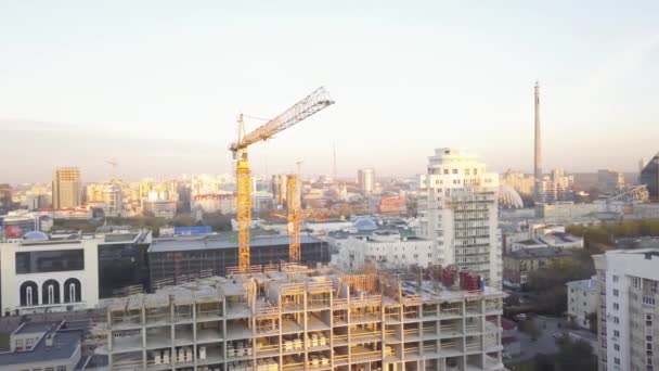 Site de construction avec grues. Vidéo. Les ouvriers de la construction construisent. Vue aérienne. Vue de dessus du chantier de construction de la ville. Construction en ville avec un manipulateur de grue — Video