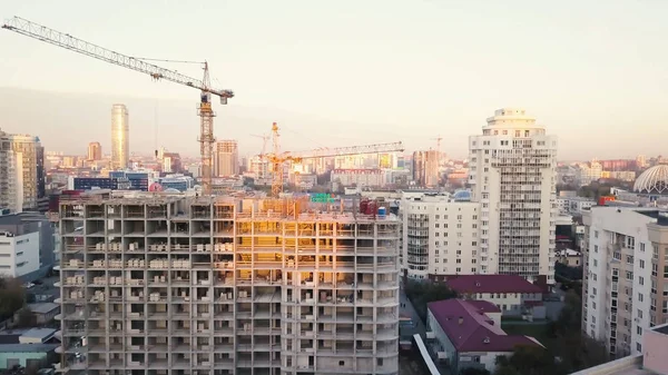 Planta de construcción con grúas. Vídeo. Los trabajadores de la construcción están construyendo. Vista aérea. Vista superior del sitio de construcción en la ciudad. Construcción en la ciudad con un manipulador de grúas —  Fotos de Stock