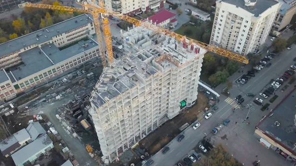 Aerial view of construction site with crane and building. Video. Top view of big development construction and architecture