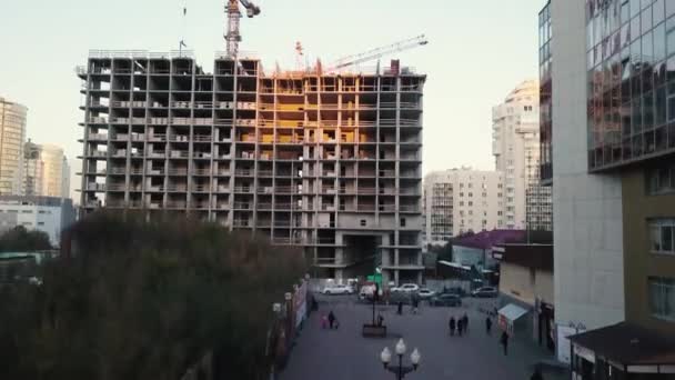 Site de construction avec grues. Vidéo. Les ouvriers de la construction construisent. Vue aérienne. Vue de dessus du chantier de construction de la ville. Construction en ville avec un manipulateur de grue — Video