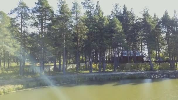Ett gammalt trähus för resten är på vattnet. Video. Dammen nära stranden och på bakgrunden av träd, natur — Stockvideo