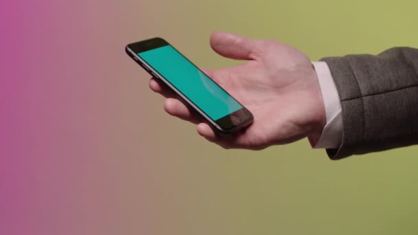Το χέρι του ένας επιχειρηματίας ο οποίος διατηρεί ένα έξυπνο τηλέφωνο. Απόθεμα. Μανίκι σακάκι και πουκάμισο μέρη. Μπλε οθόνη. Κάντε κλικ στην οθόνη του κινητού τηλεφώνου — Αρχείο Βίντεο
