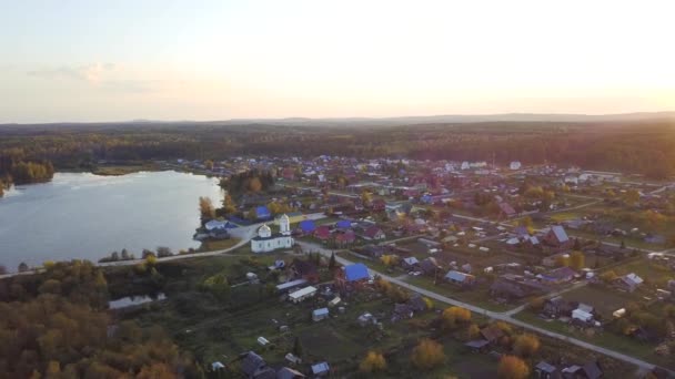 Vista superior de la pequeña ciudad turística cerca de un lago. Vídeo. Vista superior del pueblo cerca del bosque y el lago — Vídeos de Stock
