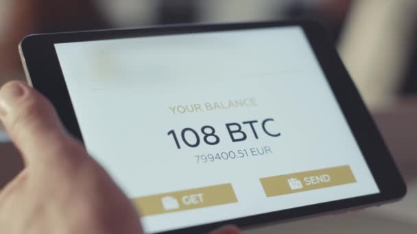 L'homme vérifie le compte sur la tablette. Des actions. Vérification du solde Bitcoin sur le compte — Video