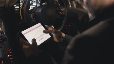 Eller arabada otururken dijital tablet kullanarak kapatın. Hisse senedi. İşadamı arabada tablet paylaşımlarda denetler