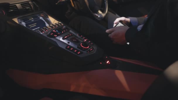 Close up of hands using digital tablet while sitting in a car. Stock. Businessman checks the shares on the tablet in the car — Stock Video