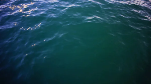 Чистое синее море, вода на фоне мыса. На складе. Морская вода на фоне солнечного дня — стоковое фото