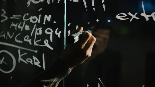 Close-up of a Man Writing Formulas on a Glass Whiteboard. Acciones. Primer plano de un científico escribiendo sobre la fórmula de vidrio — Foto de Stock