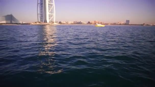 Een landschapsmening van Dubai strand en de zee in de zomer. Voorraad. Beroemde bouwen en Hengelsport boten achtergrond. Verenigde Arabische Emiraten — Stockvideo