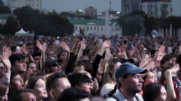 Australia - Sydney, 08.25.2019: crowd at music concert, audience raising .ands up and having fun. Action. Many people, fans enjoying music concert at the city square. — Stockfoto