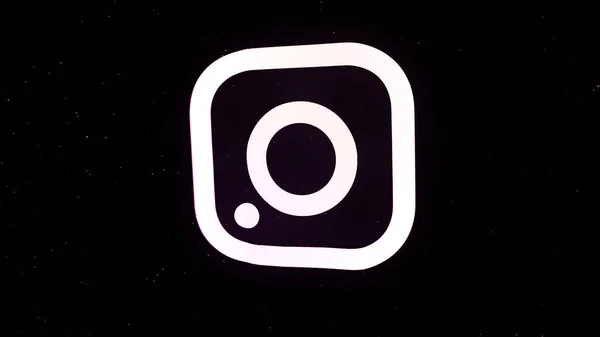 Los Angeles - EUA, 10.28.2019: O logotipo do Instagram gira e se torna uma nuvem de pequenas partículas coloridas no fundo preto. Animação. Conceito de rede social . — Fotografia de Stock