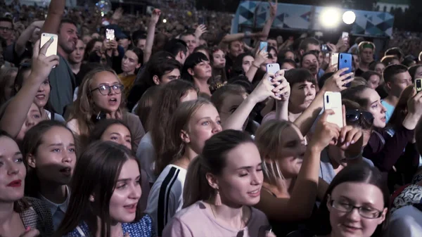 Grecja - Saloniki, 10.15.2019: osoby fotografujące smartfonem dotykowym podczas koncertu muzycznego. Akcja. Wiele szczęśliwych twarzy fanów śpiewu na festiwalu. — Zdjęcie stockowe