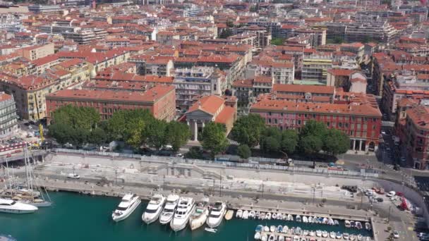 Letecký pohled na námořní přístav a přístav s luxusními jachtami v Port de Nice ve Francii v letním slunném dni. Akce. Horní pohled na bílé lodě, město a nábřeží. — Stock video