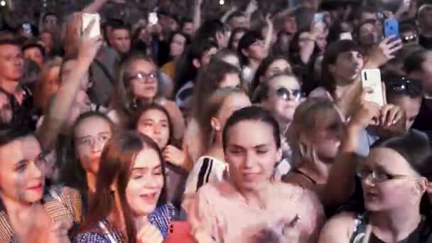 Grecia - Tesalónica, 10.15.2019: personas que toman fotografías con un teléfono inteligente táctil durante un concierto de música. Acción. Muchas caras felices de los fans cantando en el festival . — Vídeo de stock