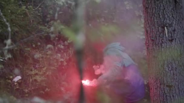 Uomo con bastone di segnale in natura. Filmati delle scorte. Il viaggiatore si è perso nella fitta foresta verde e ha acceso il segnale rosso. Bastone di segnale per il salvataggio nel caso in cui la persona si perda nel bosco — Video Stock