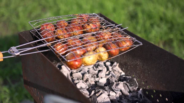 Zblízka syrové brambory na grilu venku na zeleném medově pozadí, vegetariánské jídlo. Umění. Lahodný piknik v letním slunném dni. — Stock fotografie