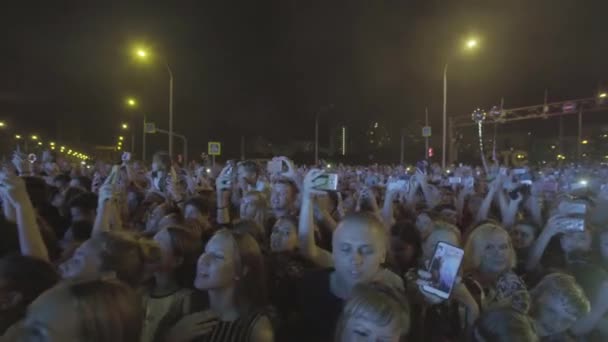 Rosja - Moskwa, 07.07.2019: Tłum na koncercie plenerowym bawiącym się w nocy. Sztuka. Ludzie robiący zdjęcia i filmy na swoich smartfonach podczas pokazu. — Wideo stockowe