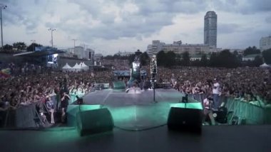 Rusya - Moskova, 09.12.2019: Rap ya da Hip-Hop müzisyeni tezahürat yapan kalabalığın önünde sahneye çıkıyor. Başla. Konser sırasında bir sanatçının arka görüntüsü.