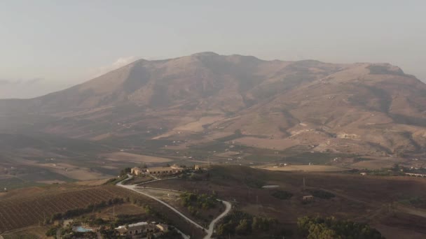 Impresionante paisaje con una gran montaña cubierta de niebla y verde valle a sus pies. Acción. Aérea del pico nublado de la montaña y el pueblo . — Vídeo de stock