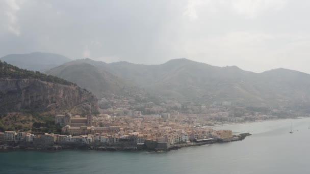 Vista panorámica aérea de una ciudad costera cerca de las montañas sobre un fondo nublado. Acción. Hermoso paisaje de la orilla del mar y la pequeña ciudad . — Vídeos de Stock