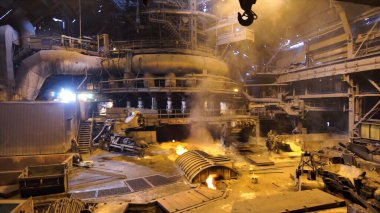 Sıcak atölyedeki fabrika işçilerine yaklaşan kamera, ağır endüstri konsepti. Stock Video. Metalürji endüstrisi, çelik üretim süreci.