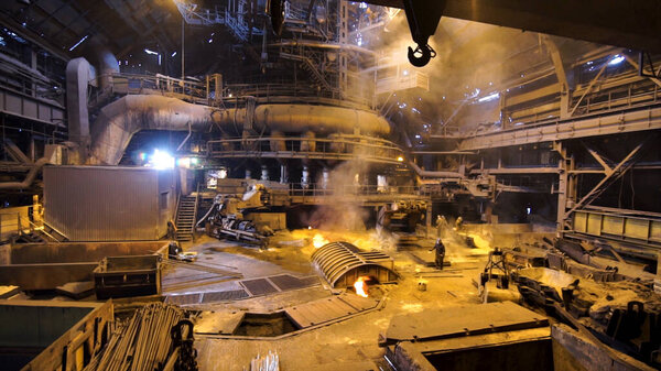 Camera moving backwards at the factory workers at the hot workshop, heavy industry concept. Stock Footage. Metallurgical industry, steelmaking process.