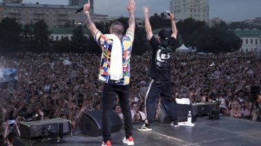 İspanya - Barselona, 07.09.2019: konser sırasında sahnede tokalaşan iki rapçinin arka görüntüsü. Başla. Festivalde canlı performans sergileyen iki hip-hop sanatçısı.