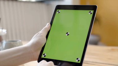 Yeşil ekranda tabletle çalışan bir adam. Stok görüntüleri. Yeşil tablet ekranına dokunarak ve bastırarak pürüzsüz elleri yakınlaştır