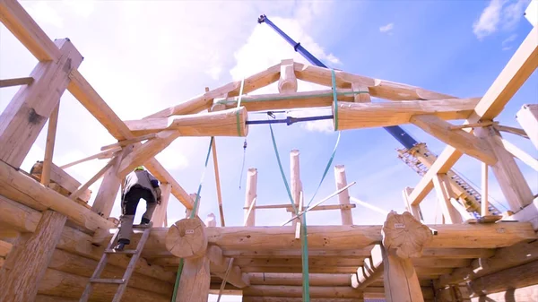 Un cadre de maison contre un ciel bleu. Clip. Le cadre du bâtiment au début de la construction de la maison à partir de poutres en bois de forme cylindrique . — Photo