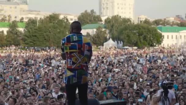 Ekaterinburg, Rusia - agosto, 2019: Vista desde el escenario con el canto de los fans de la gente. Acción. Actuación en el escenario en unas vacaciones en la ciudad — Vídeos de Stock