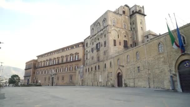 Gammal historisk byggnad med fästning vägg med vandrande turister på bakgrunden av himlen. Börja. Grå hög gammal byggnad i Europas historiska stad — Stockvideo