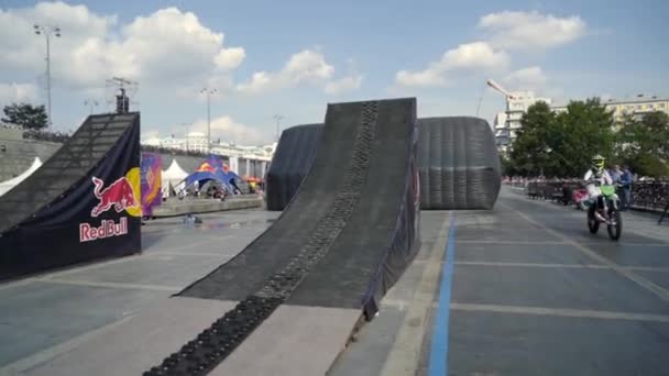 Motorista realiza acrobacias con salto en el festival de Moto. Acción. Actuación con moto y moto de nieve en trampolín del festival Moto — Vídeo de stock