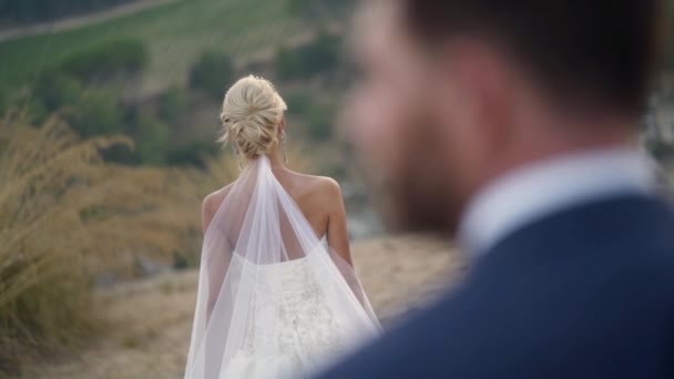 Θέα από το πίσω μέρος του γαμπρού στην όμορφη νύφη. Πάμε. Κοντινό πλάνο δύο νεόνυμφων σε σκέψη πριν από την τελετή στον καθαρό αέρα. Ενθουσιασμός ζευγαριών νεόνυμφων πριν το γάμο — Αρχείο Βίντεο