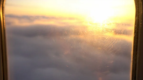 Céu bonito, nuvens e céu por do sol atrás da janela do avião, viajando e conceito de transporte aéreo. Filmagem. Voando acima do céu dourado brilhante e nuvens brancas . — Fotografia de Stock