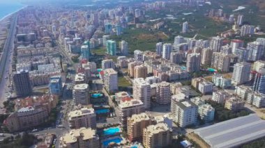 Güneşli bir yaz gününde inanılmaz bir sahil kasabasının havadan görünüşü. - Sanat. Bir sürü oteli, yüzme havuzları, mavi güzel denizi ve parlak gökyüzü olan bir kasabanın en güzel manzarası..