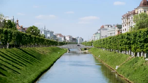 川沿いの緑の木々や白い家がある街の美しい景色。ストック映像だ中世ヨーロッパの旧市街の川の運河沿いのロマンチックな家. — ストック動画