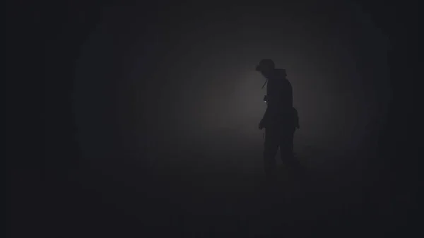 Silhouet van de mens in dikke mist. Voorraadbeelden. Zwart silhouet van de mens met een zaklamp die schijnt in dikke grijze rook. Man met zaklamp baant zich een weg door duisternis in rook — Stockfoto