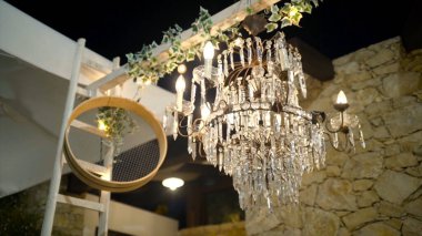 Geceleri kristalleri parlayan güzel bir avize. Başla. Romantik ve eski avizeler kristallerle parlıyor arka plandaki balkonun açık boşluğunda gece gökyüzünde