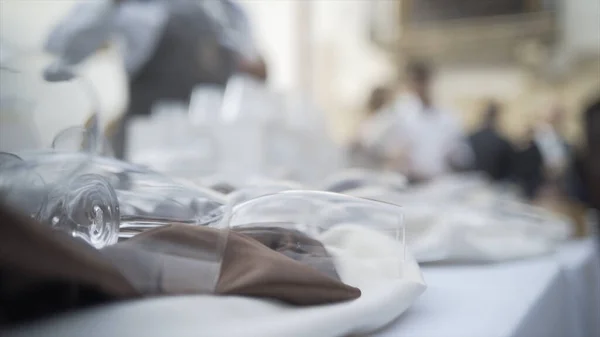 Primer plano de hermosas gafas tumbadas en la mesa de vacaciones. Acción. Hermosa porción con vasos transparentes para vacaciones o ceremonias importantes — Foto de Stock