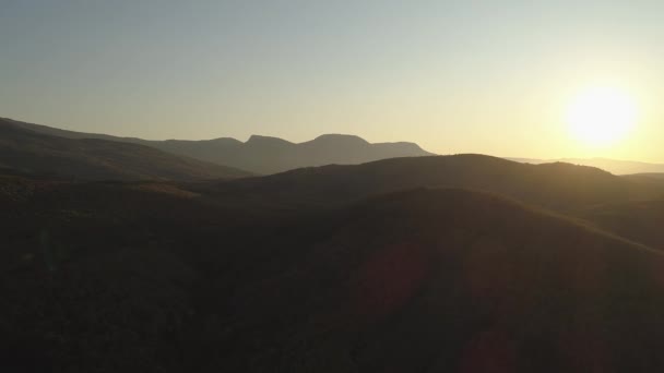 Bovenaanzicht van het bergbos bij de zon. Neergeschoten. Bovenaanzicht van het heuvelachtige gebied in het zonlicht — Stockvideo